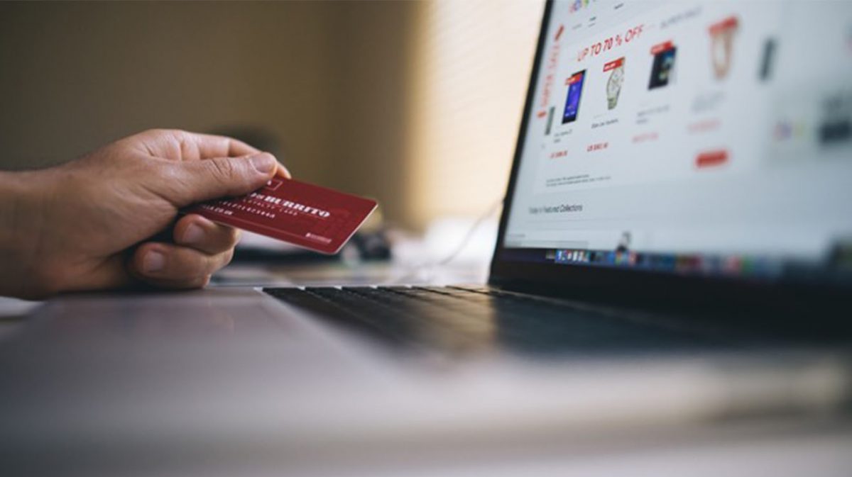 Person holding credit card at computer